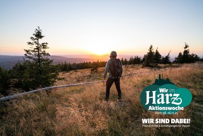 Wanderer blickt bei Sonnenuntergang über die Landschaft im Harz