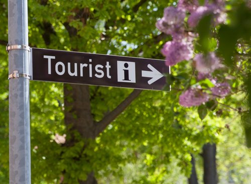 Nahaufnahme eines Straßenschildes mit der Aufschrift "Tourist-Information"