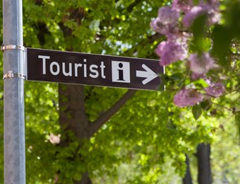 Nahaufnahme eines Straßenschildes mit der Aufschrift "Tourist-Information"
