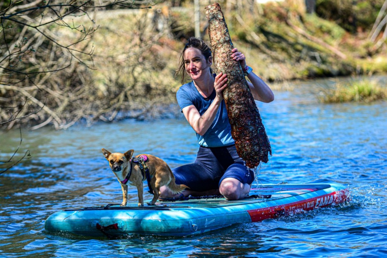 Frau mit Hund auf SUP