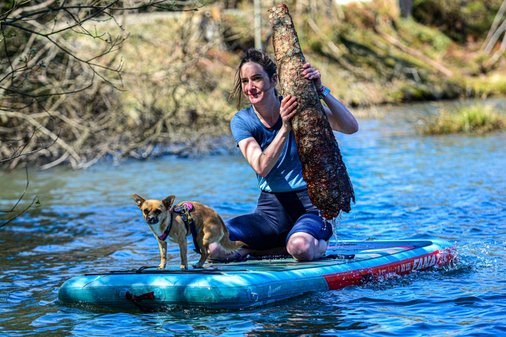 Frau mit Hund auf SUP