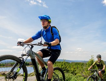 Zwei Mountainbiker fahren einen Berg hinauf bei sonnigem Wetter