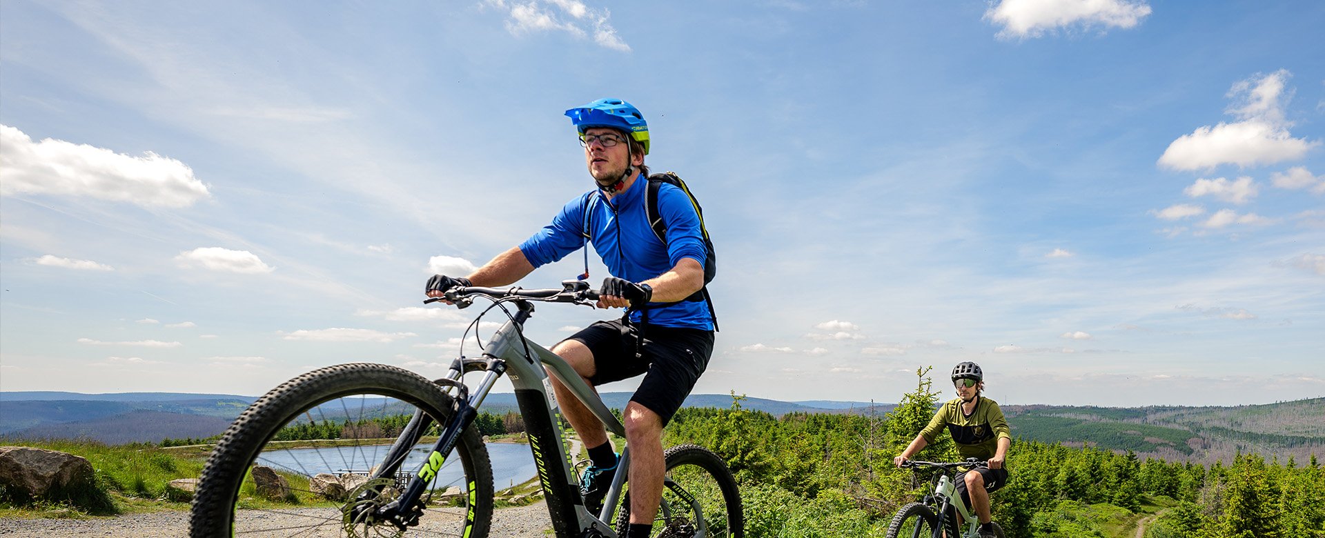 Zwei Mountainbiker fahren einen Berg hinauf bei sonnigem Wetter