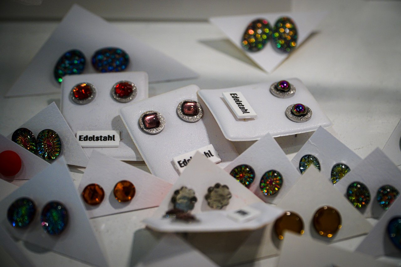 Nahaufnahme von verschiedenen Ohrringen oder Anstecker mit glitzernden Steinen