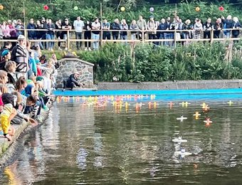 Gäste setzen Lichterschiffe aus dem Teich aus 