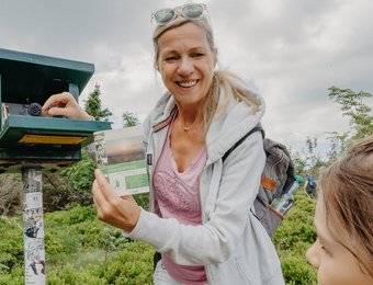 Frau und Kind stehen am Stempelkasten