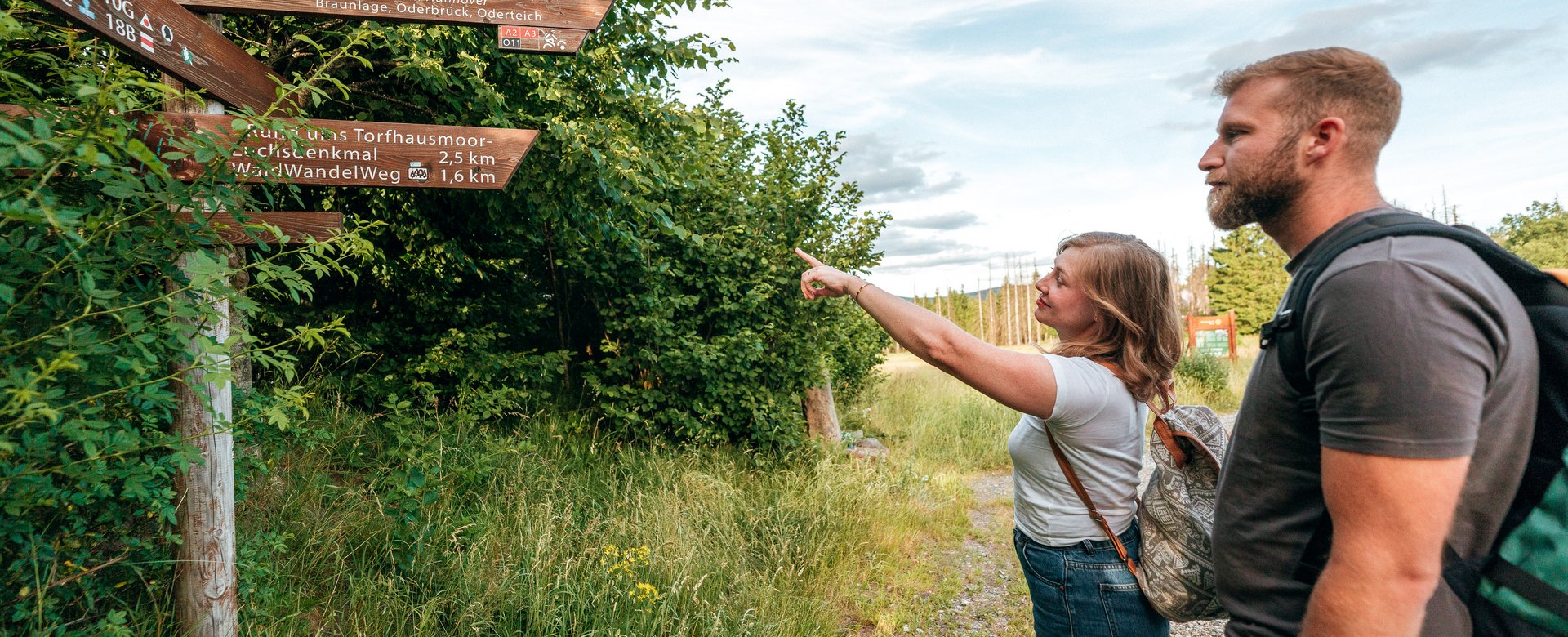 Mann und Frau schauen auf Schild, Frau zeigt auf das Schild