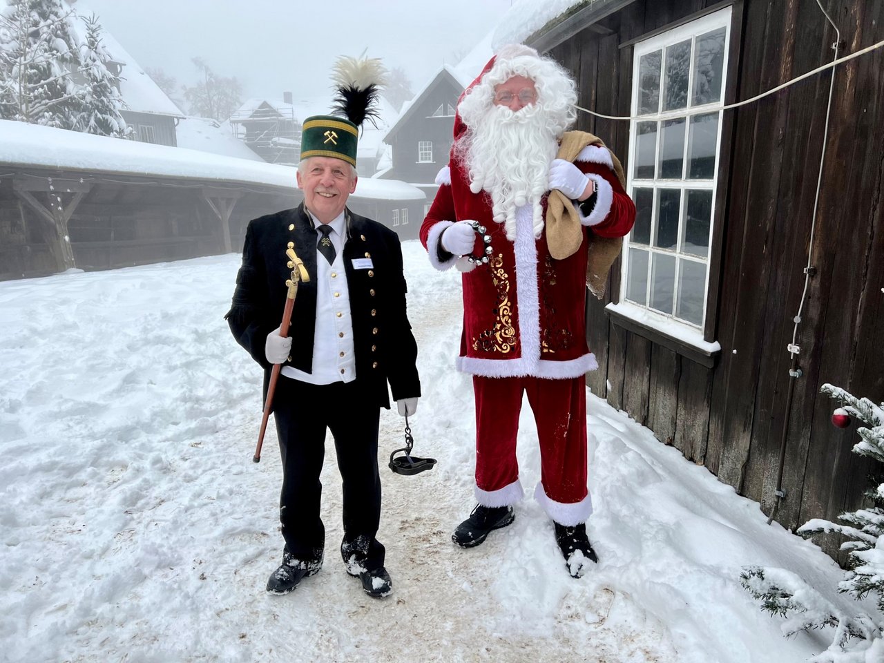 Weihnachtsmann und Bergmann stehen nebeneinander und schauen in Kamera