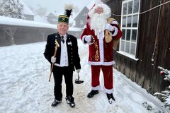 Weihnachtsmann und Bergmann stehen nebeneinander und schauen in Kamera
