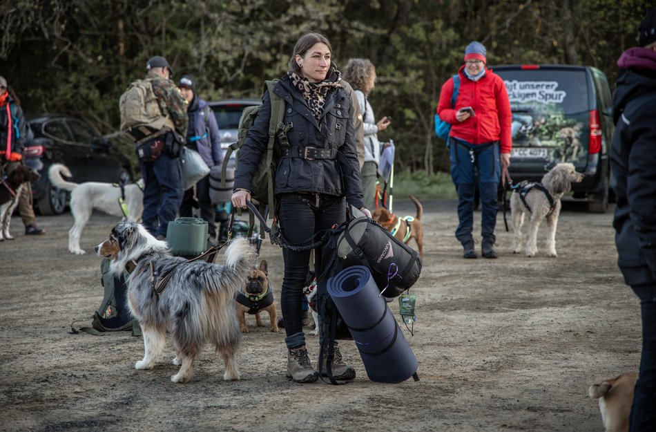 Teilnehmer warten mit ihrem Hund 