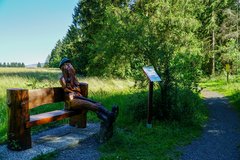Geschnitzte Bank mit Wanderer 