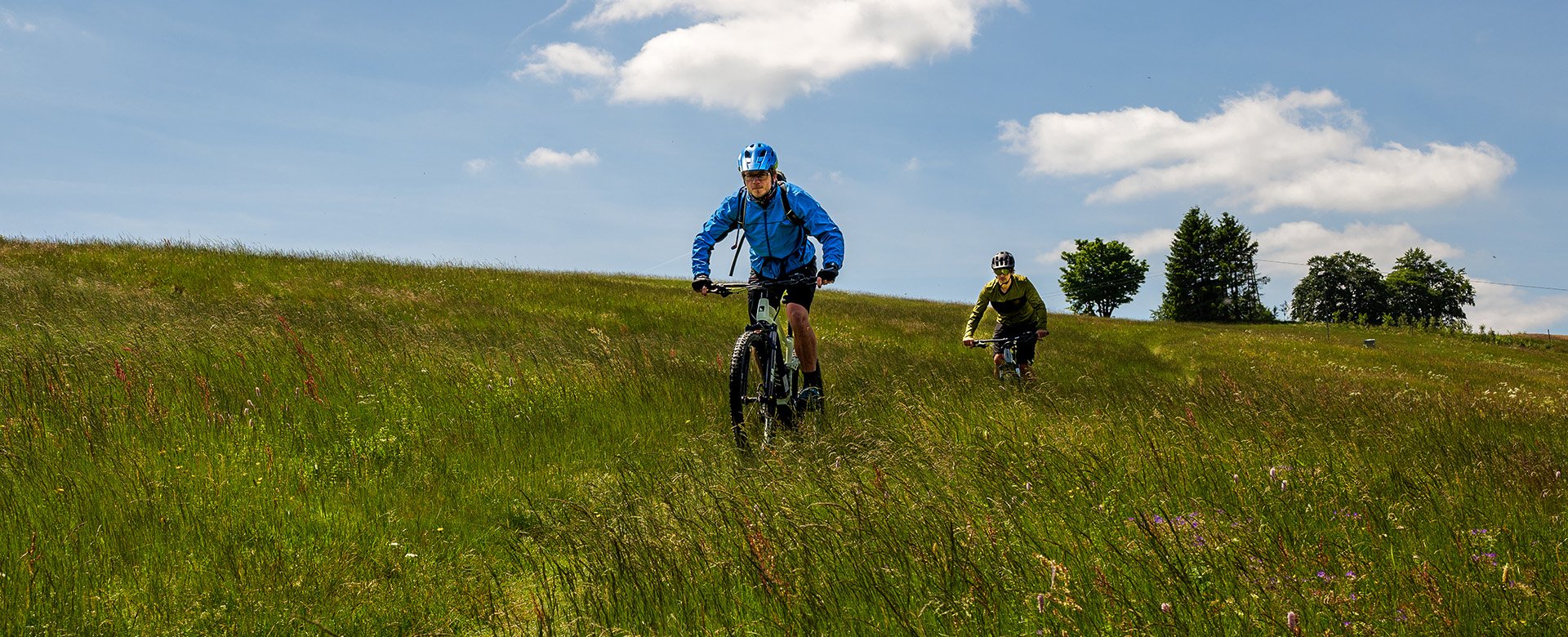 Zwei Radfahrer fahren Offroad quer über eine Wiese