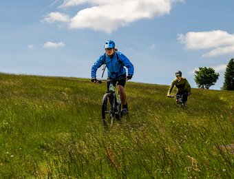 Zwei Radfahrer fahren Offroad quer über eine Wiese