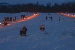 beleuchtete Skiwiese beim Fackelrodeln