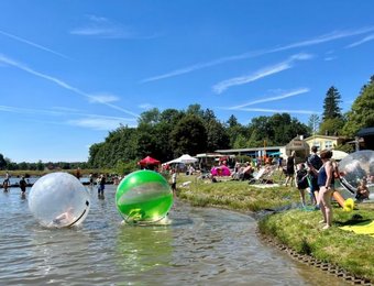 Blick auf die großen Wasserbälle und Gäste im Wasser 