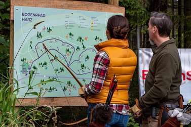 Frau und Mann schauen auf Übersichtskarte des Bogen Parcours