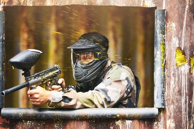 Mann spielt Paintball und schießt zurück
