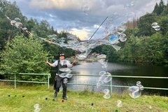 Ein Seifenblasenkünstler macht große Seifenblasen am Okerteich 