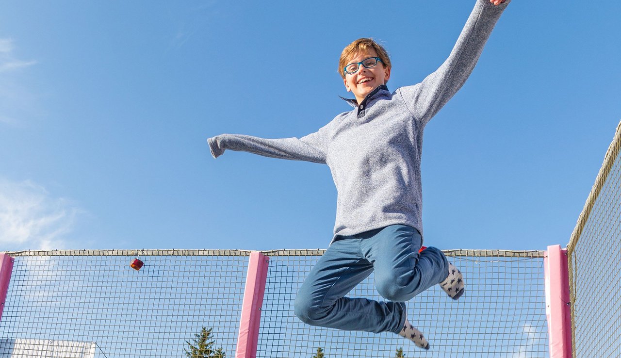Kind springt auf Trampolin