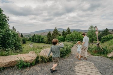 Eine Familie läuft in Torfhaus auf dem Bohlenweg