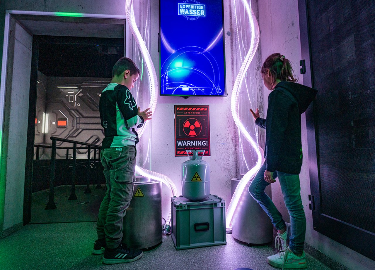 Kinder stehen vor dem Eingang in das 5D Kino Prof. Fallwasser