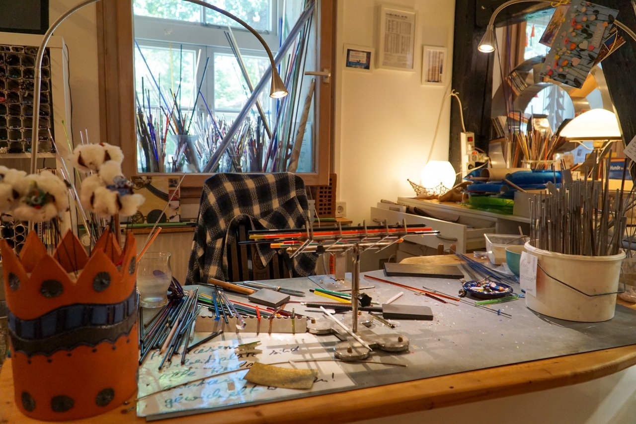 Blick auf einen Arbeitstisch mit verschiedenen DIY Werkzeugen, Stiften und Pinseln