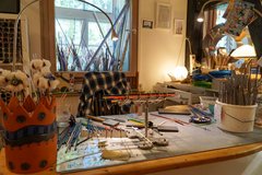 Blick auf einen Arbeitstisch mit verschiedenen DIY Werkzeugen, Stiften und Pinseln