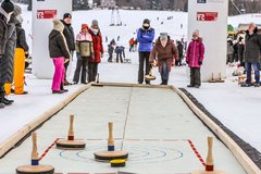 Familien spielen Eisstock schießen 