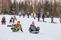 Leute rodeln den Hang hinunter 