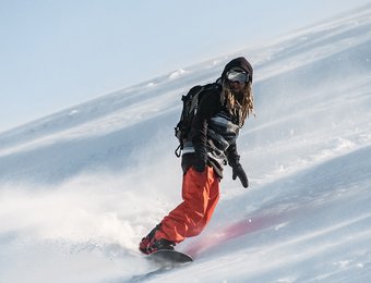 Snowboardfahrer fährt eine Piste hinunter