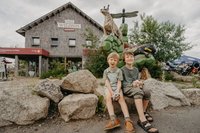 Zwei Kinder sitzen vor dem Nationalpark-Informationszentrum 