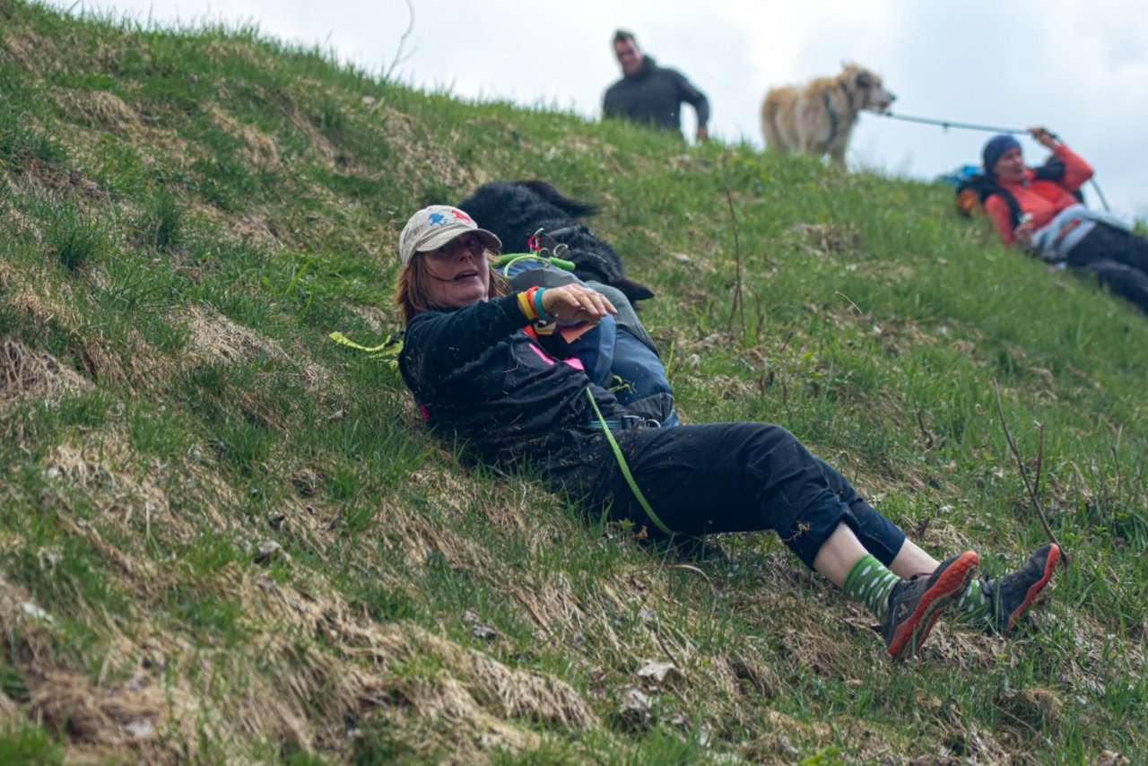 Frau liegt auf Wiese mit Hund