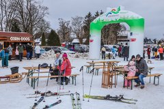 Wintergaudi auf der Skiwiese: Leute sitzen auf Bank und ruhen aus 