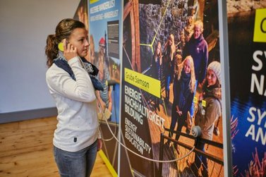 Eine Frau hört Informationen in der Ausstellung zum Welterbe im Harz