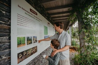 Vater und Sohn schauen auf eine Informationstafel