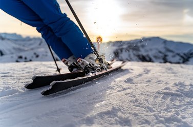 Nahaufname von einem Skifahrer welcher sich in eine Kurve lehnt