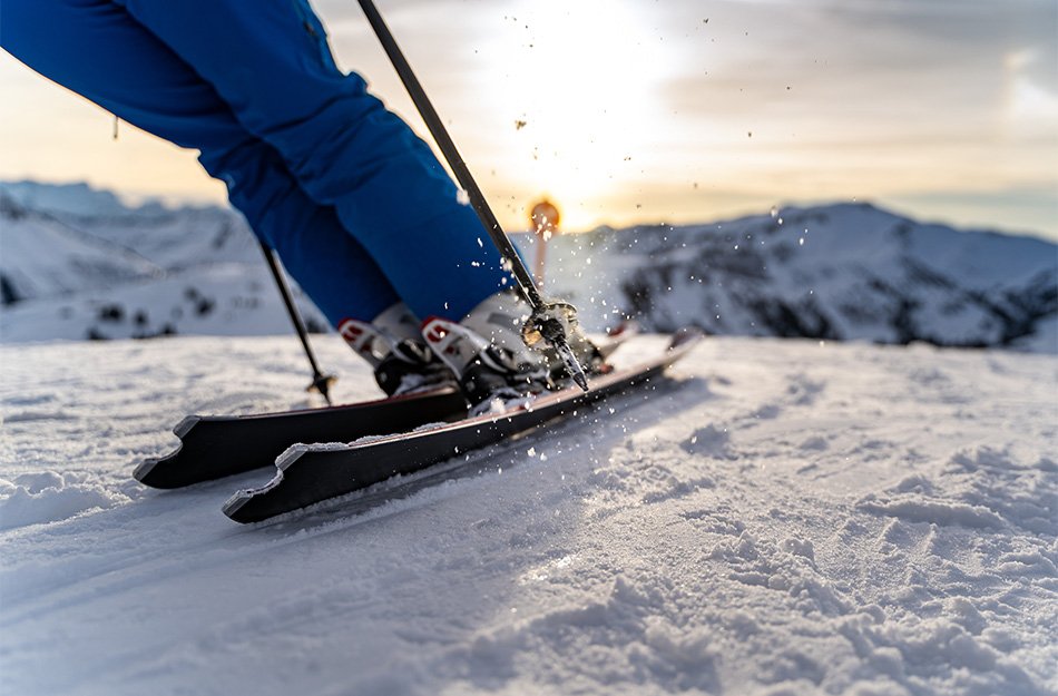 Nahaufname von einem Skifahrer welcher sich in eine Kurve lehnt