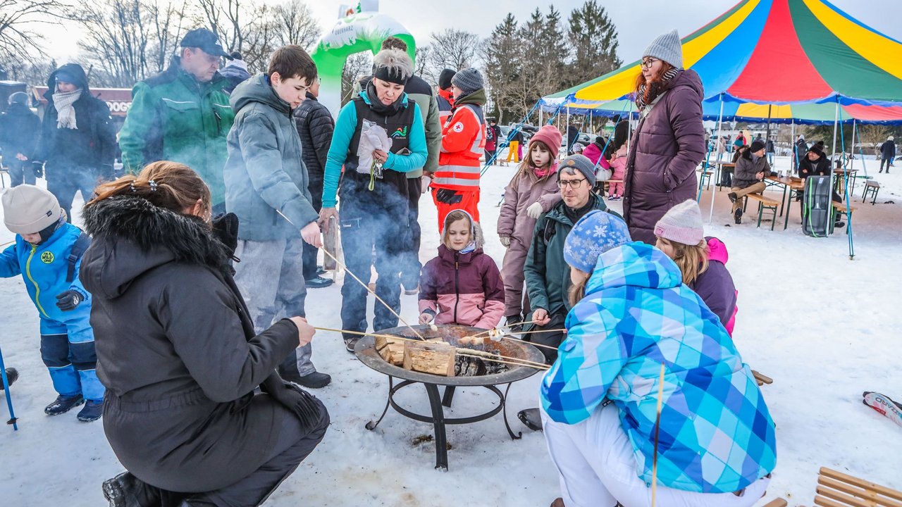 Kinder und Erwachsene backen Stockbrot am Feuer