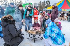 Kinder und Erwachsene backen Stockbrot am Feuer