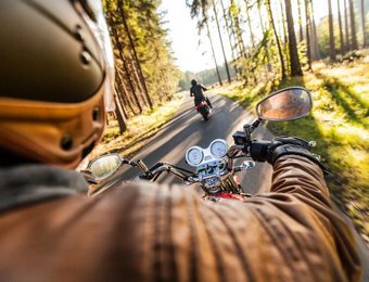Über Schulterblick eines Motorradfahrers fahrend auf einer Straße hinter einem anderen Motorradfahrer