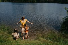 Mutter mit drei Kindern steht Fußtief im Wasser am See