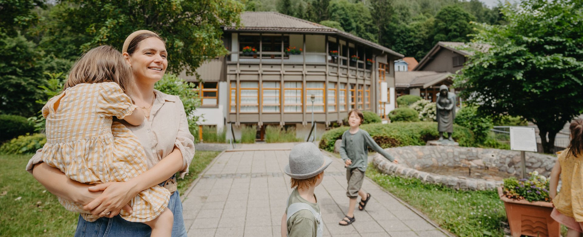 Mutter mit 3 Kindern geht im Park spazieren