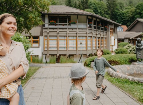 Mutter mit 3 Kindern geht im Park spazieren