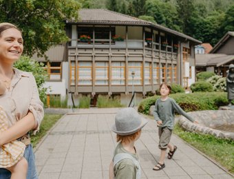 Mutter mit 3 Kindern geht im Park spazieren