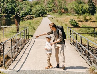 Zwei Personen Wandern über eine Brücke am Teich