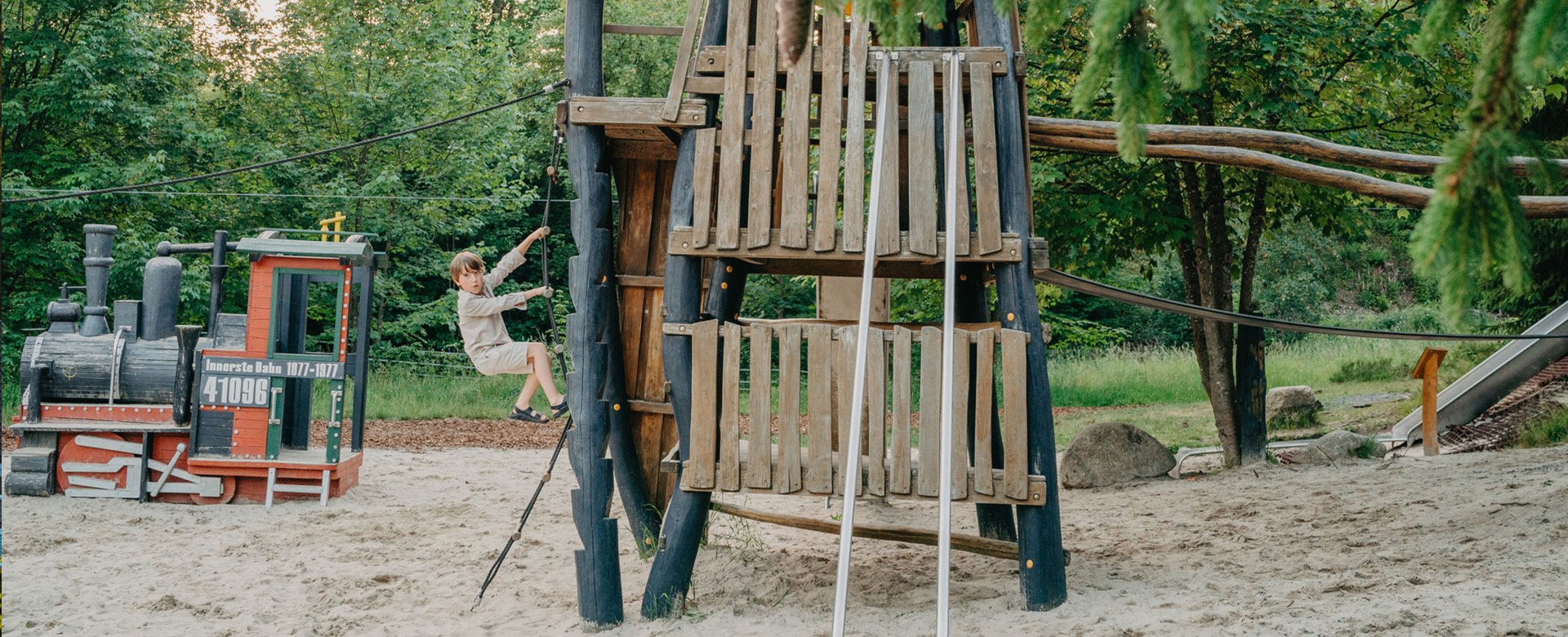 Junge klettert am Robinson Abenteuer Spielplatz