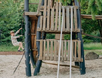 Junge klettert am Robinson Abenteuer Spielplatz