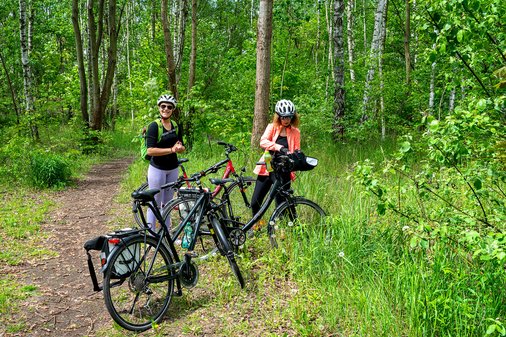 Zwei Frauen machen eine Pause mit dem Rad im Wald